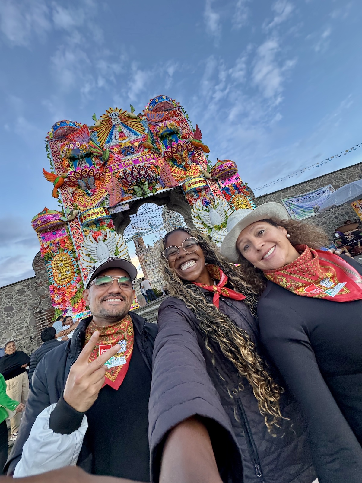 Smiling with new ATMEX friends at a multi-colored gate leading to a temple.