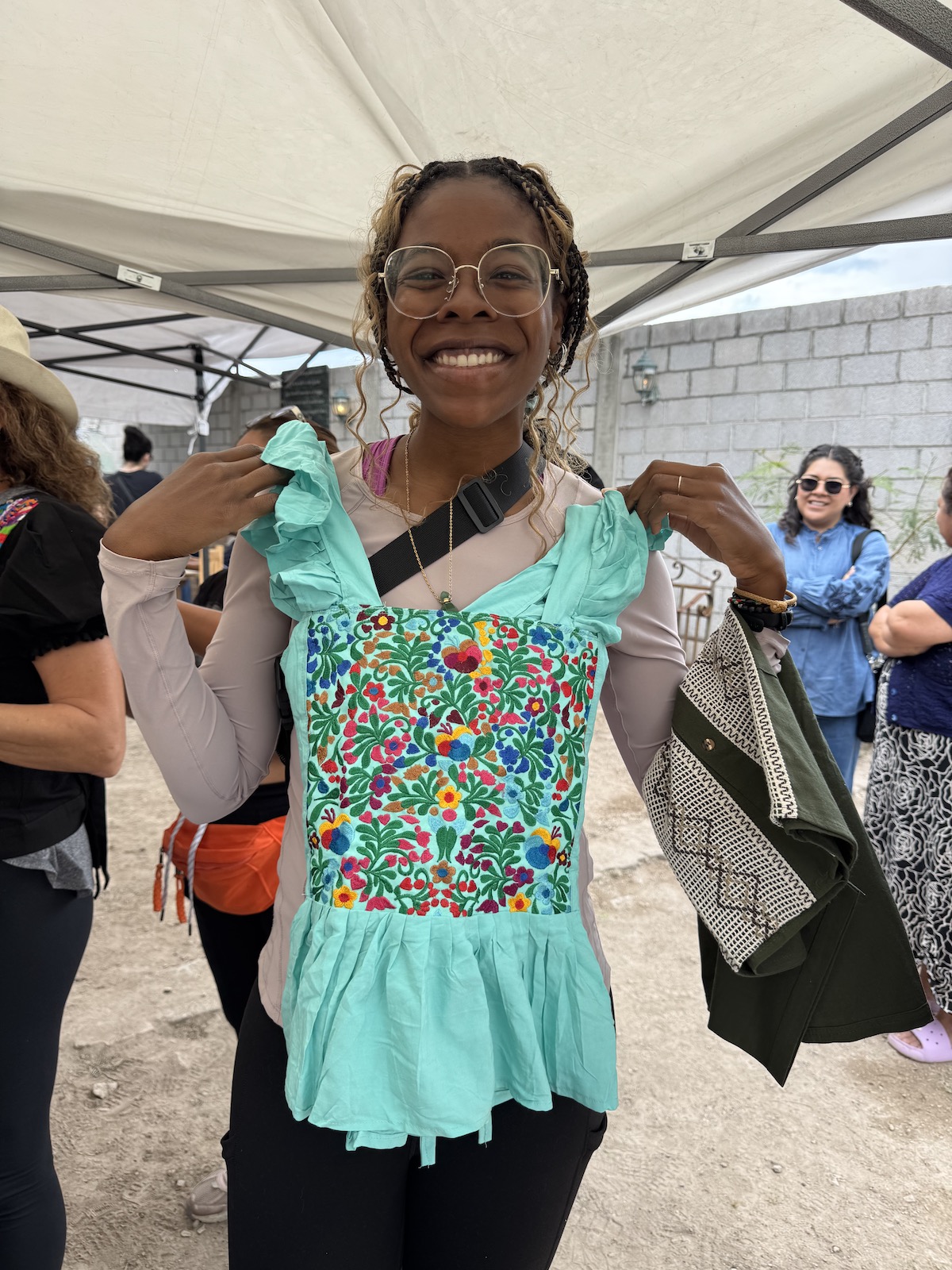 A photo of me holding a handmade embroidered turquoise shirt.  