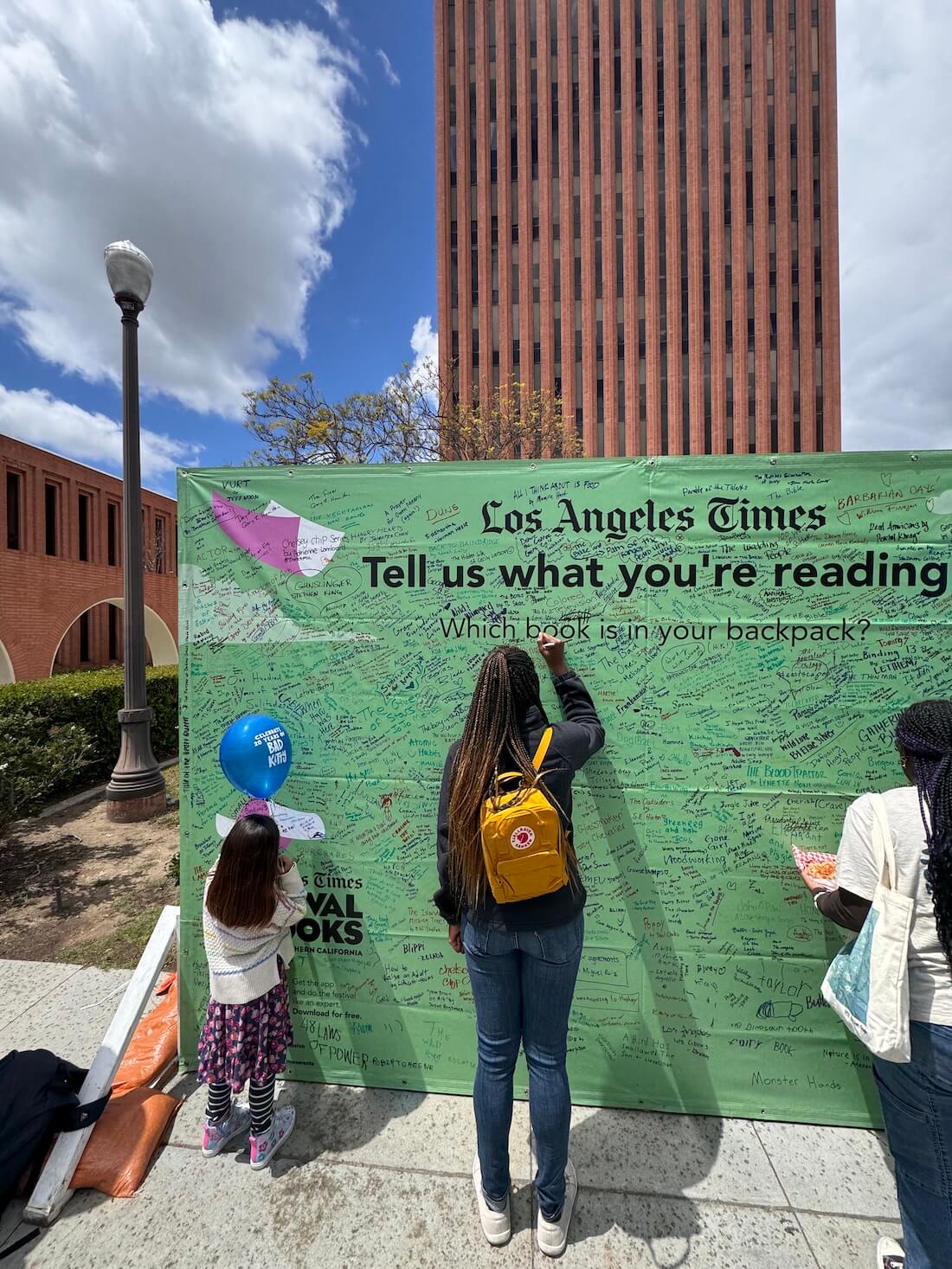 A photo of me writing on a reading wall at USC during the LA Times Book Festival.